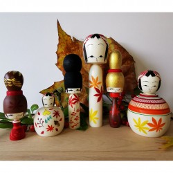 5- Kokeshi with two yellow and orange leaves. Autumn ejiko kokeshi by  Wagatsuma Noboru.